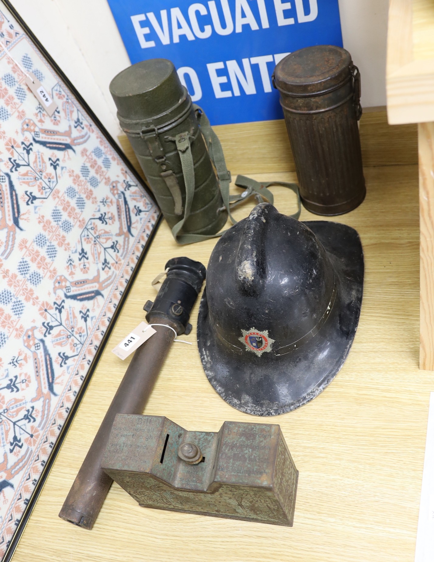 A WW2 gas mask in original metal case, together with other related ephemera, including an enamelled sign, a fire brigade hat, etc.